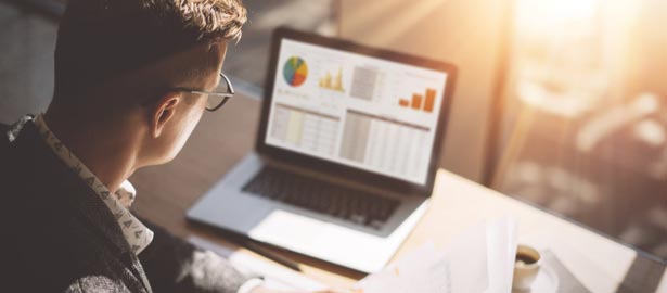 Un homme travaille de chez lui, sur un bureau.