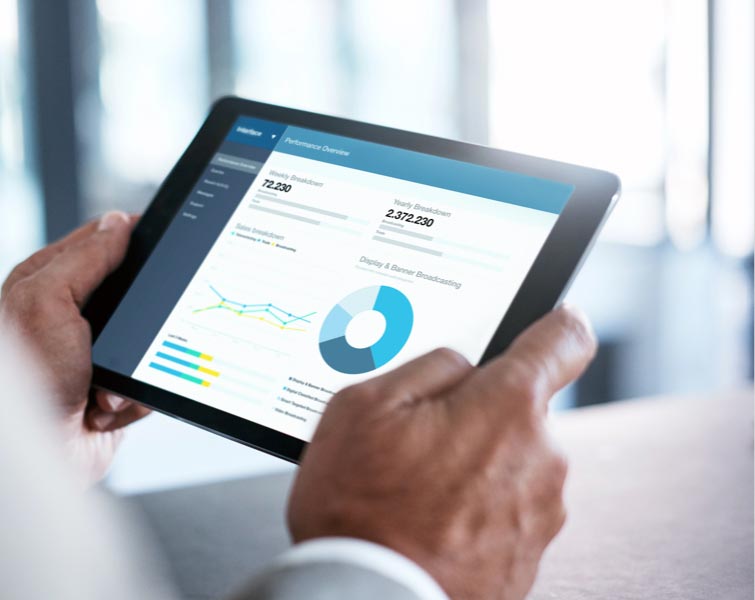 A person holding a tablet device that displays circle graphs.