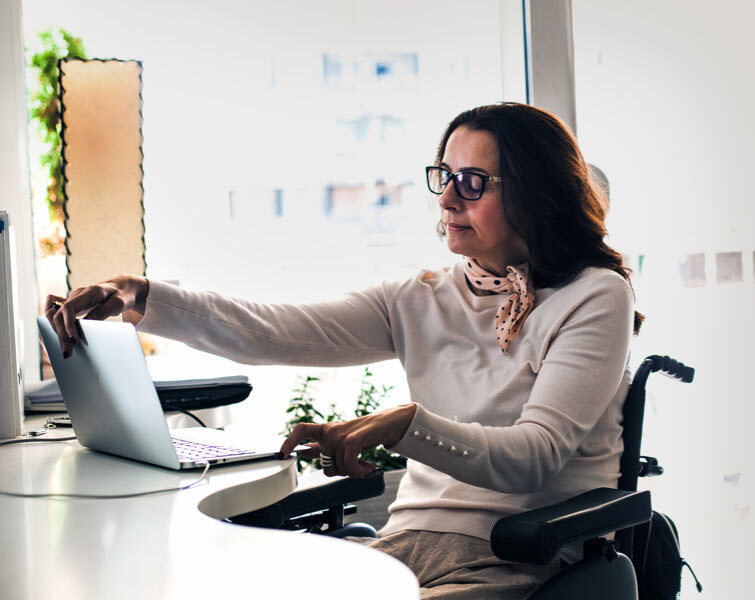 Une femme ouvre son ordinateur portable.