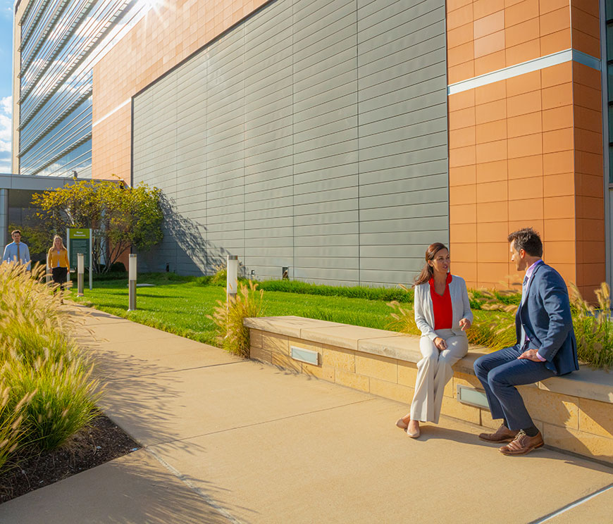 Two Edward Jones's workers sitting outside of Corporate south buiding