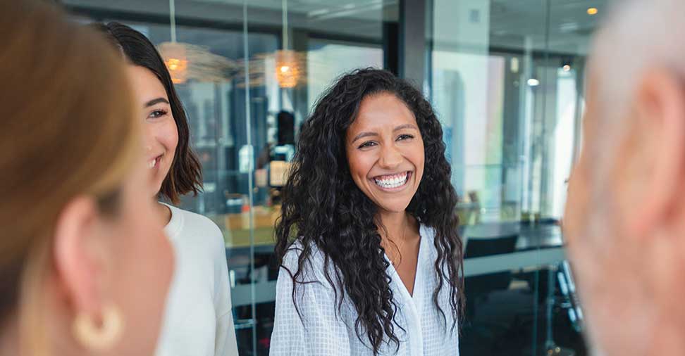Business woman smiling and interacting with colleagues