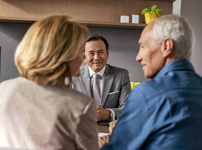 Financial advisor behind desk talking to couple