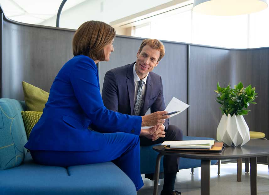 Two professionals having a discussion in an office.
