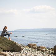 Woman relaxing on a rocky beach.