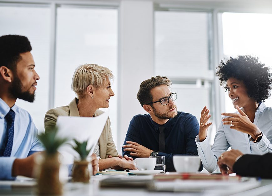 Team members sitting around a table working collaboratively.