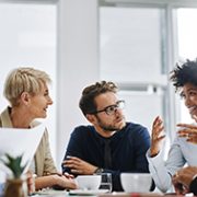 Team members sitting around a table working collaboratively.