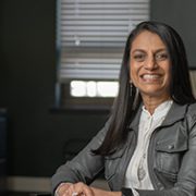 Binita Kraus sitting in a chair smiling.