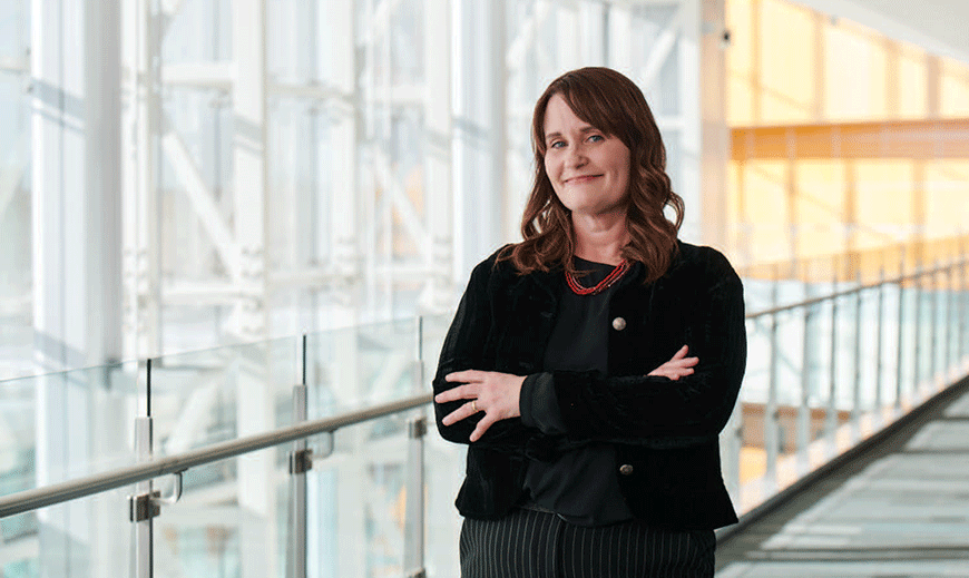 Monica Reha standing with arm crossed at Edward Jones headquarter.