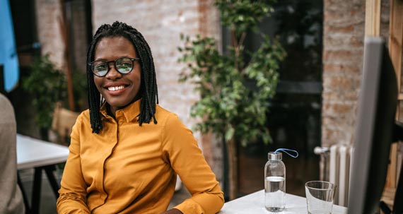 A smiling woman seated at a table.