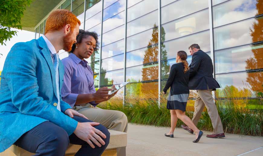 Professional man and woman having a discussion outside.