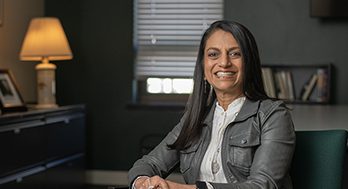 Binita Kraus sitting in a chair smiling.