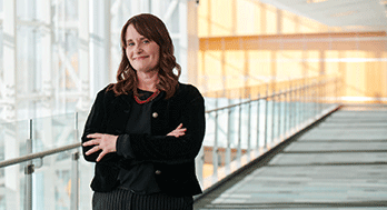 Monica Reha standing with arm crossed at Edward Jones headquarter.