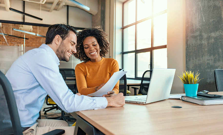 Two financial advisors discussing at a table.
