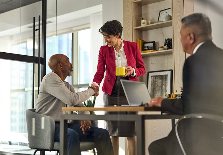 Financial advisors and branch office person in an office meeting client.