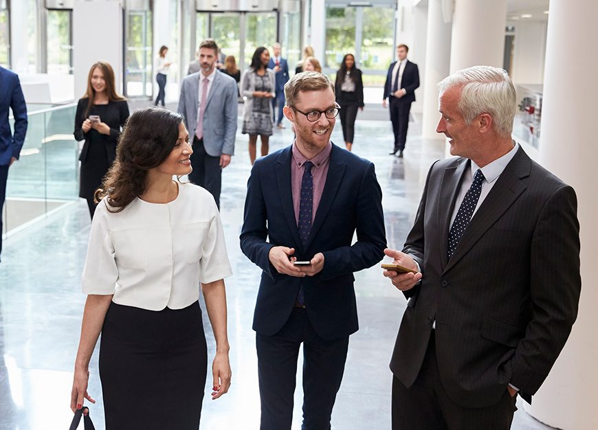 Two men and a woman walking and talking.